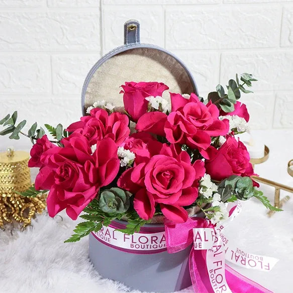 10 dark pink roses and white statice in grey flower box closeup view