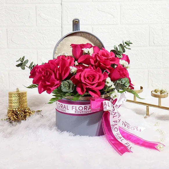 10 dark pink roses and white statice in grey flower box front view