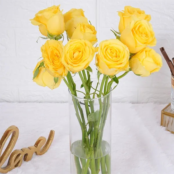 10 yellow roses in long glass jar close up view 2