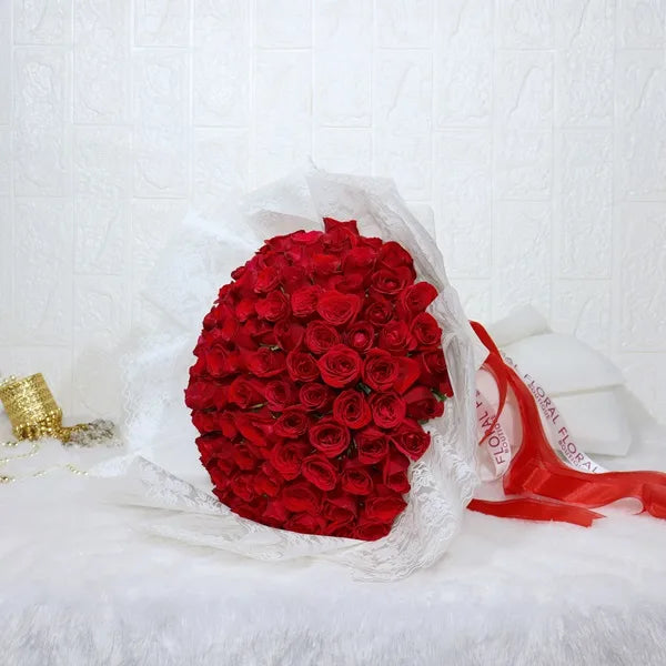 100 red roses bouquet wrapped in white paper close up view