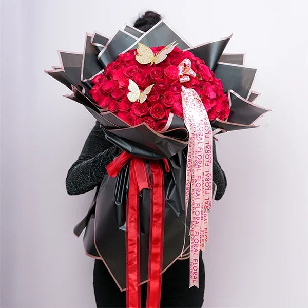 100 red roses bouquet wrapped in black paper with pink edges top view 2