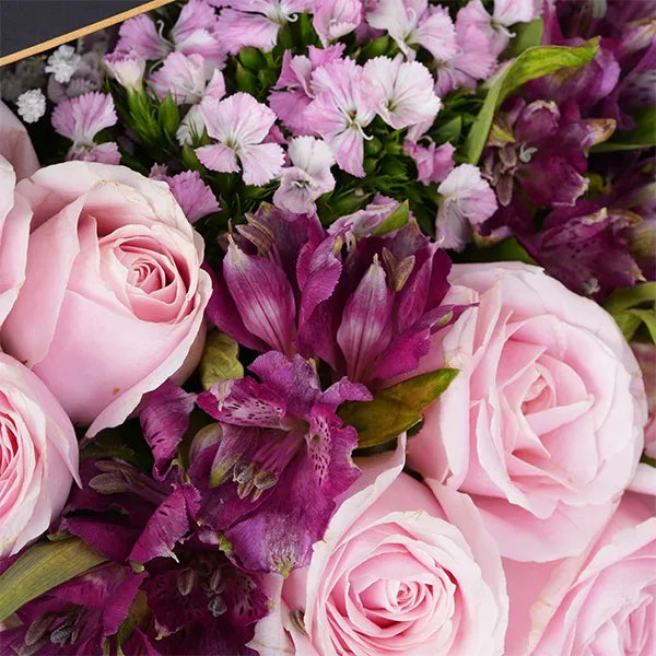 a beautiful mix of pink purple and white flowers in a gift box close up view 2