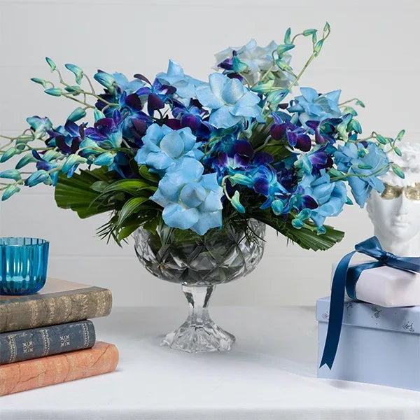 blue orchid and rose arrangement in crystal vase front view
