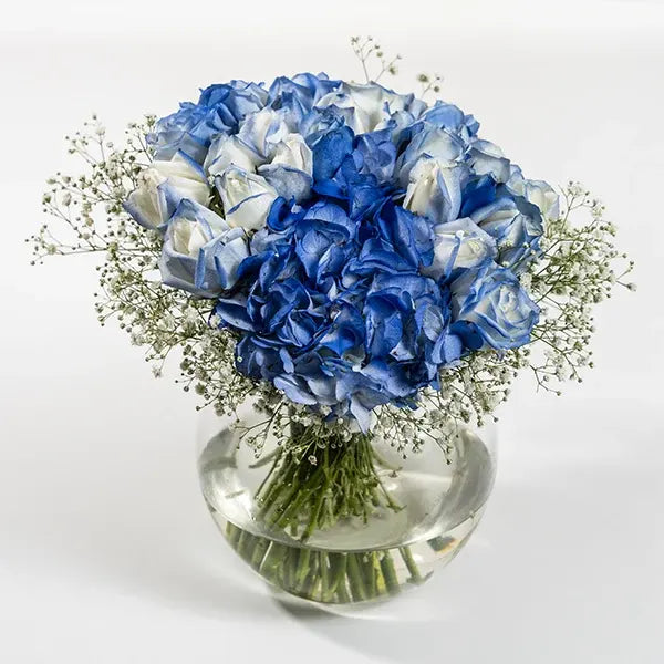 23 blue roses with hydrangea in a fish bowl front view