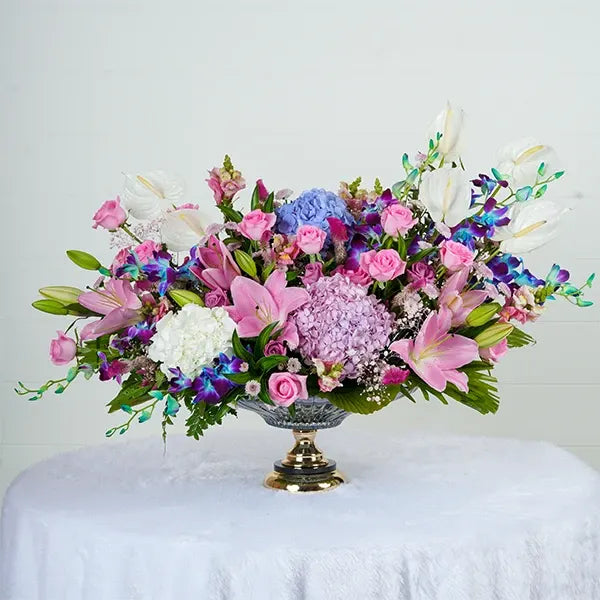 glass vase with white anthuriums hydrangeas oriental lilies blue orchids pink button chrysanthemums front view