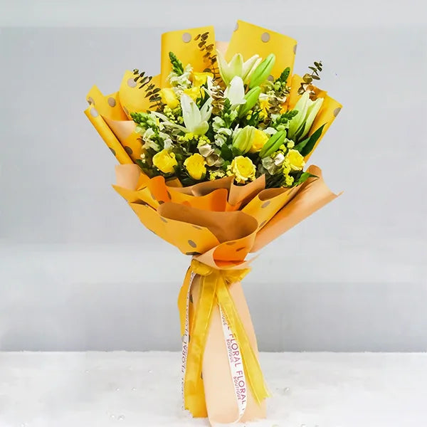 white asiatic lilies and yellow roses bouquet in yellow dot paper front view