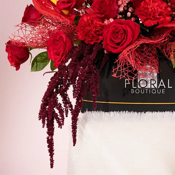 red flower box arrangement of 20 red roses with red carnations side close up view 2
