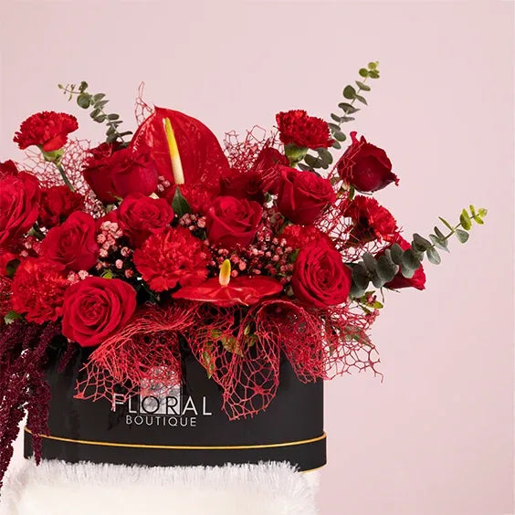 red flower box arrangement of 20 red roses with red carnations side view 2