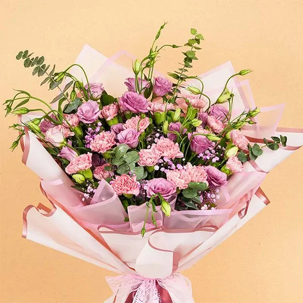 mixed bouquet wrapped in pink for mothers day close up view