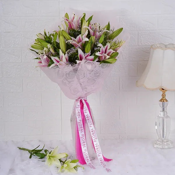 oriental lily bouquet warped in pale pink paper front view