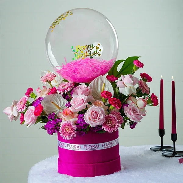 pink box with sweet avalanche red jumelia roses dark pink carnations clear balloon front view