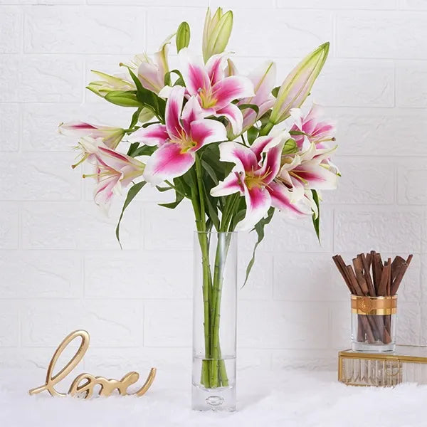 5 oriental lilies in long glass jar front view