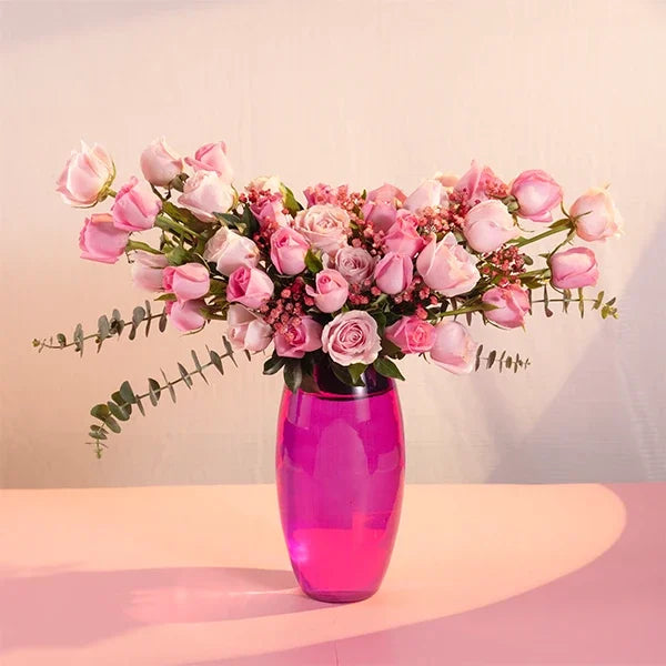 pink roses in a pink glass vase front view