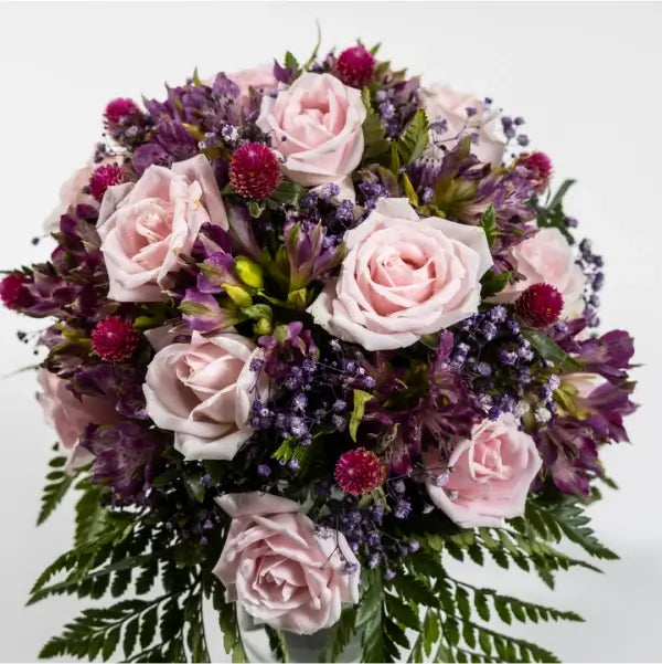 pink roses with purple alstroemeria in a glass vase top view