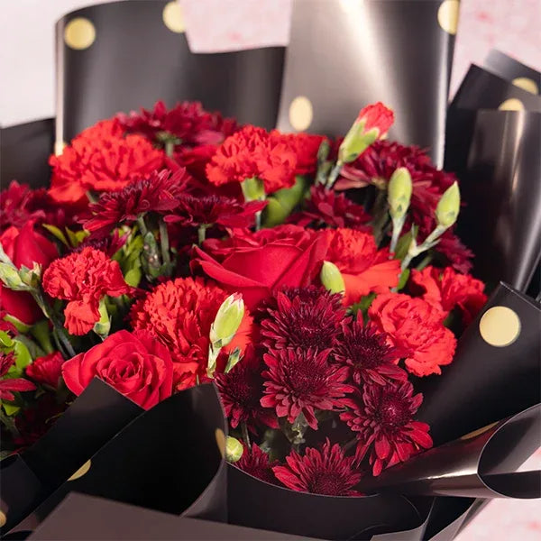 bouquet of red chrysanthemums carnations and roses close up view
