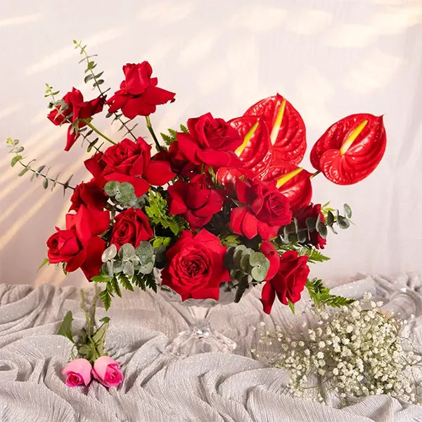 red roses and anthurium in a glass vase front view