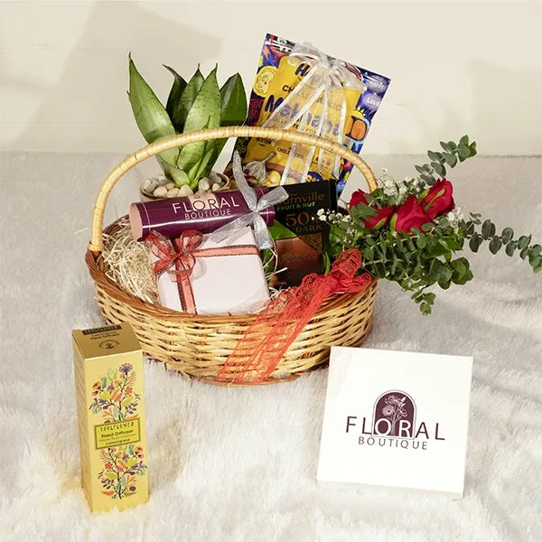 woven basket hamper with fresh flowers chocolates and assorted snacks front view 2