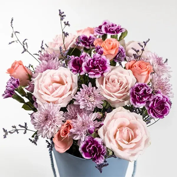 sweet avalanche baby pink roses with spray carnations in a cone shaped box top view