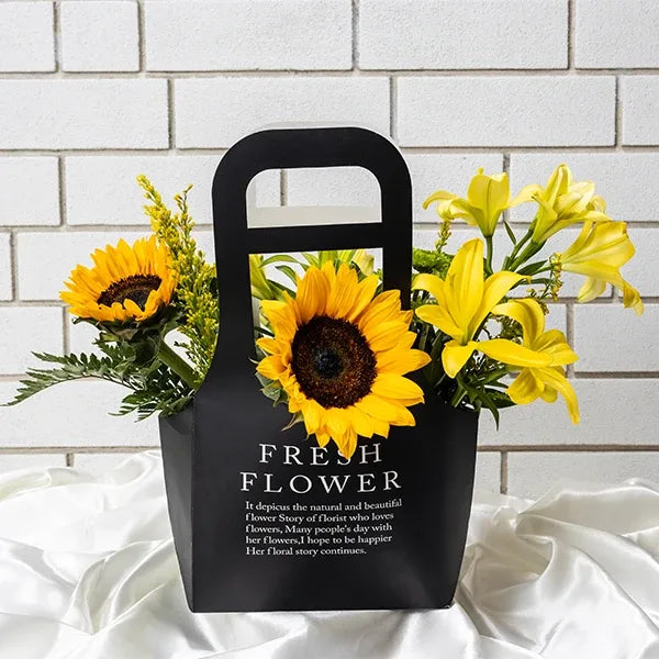 yellow lilies and sunflowers in a black paper box top view 2