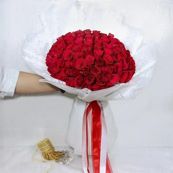 100 red roses bouquet wrapped in white paper top view