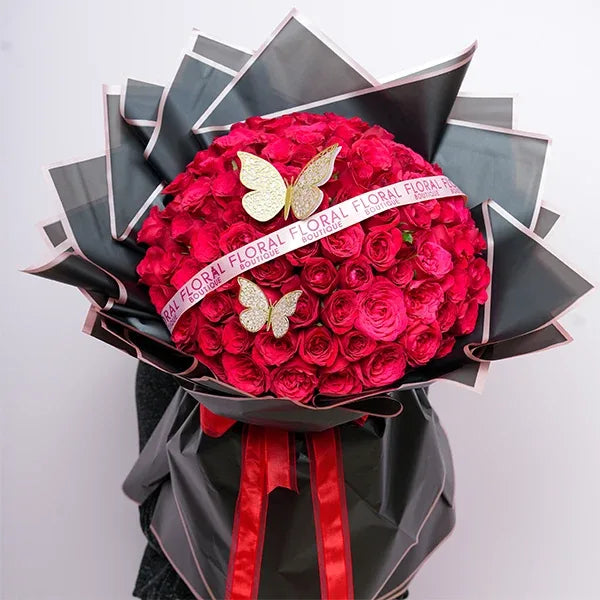 100 red roses bouquet wrapped in black paper with pink edges top view