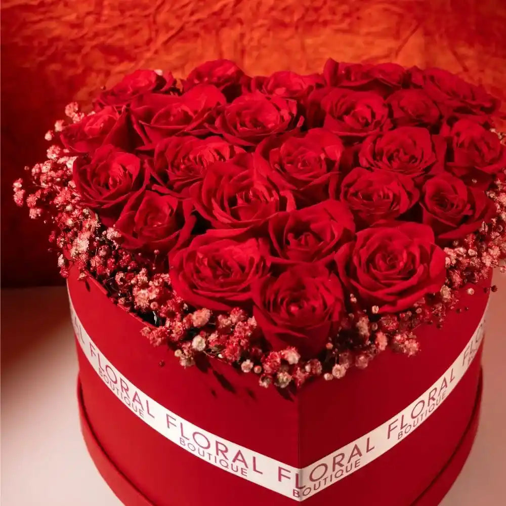 25 red roses in a red heart shaped box close up view