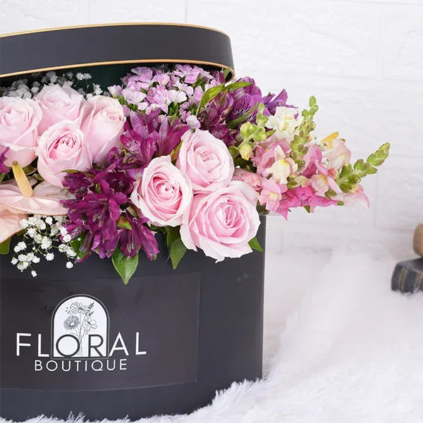 a beautiful mix of pink purple and white flowers in a gift box close up view