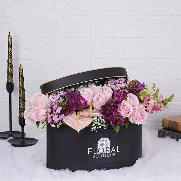 a beautiful mix of pink purple and white flowers in a gift box front view 2