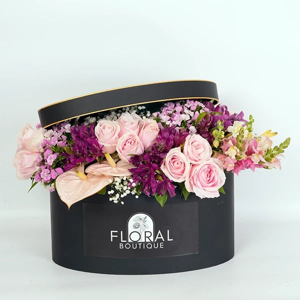a beautiful mix of pink purple and white flowers in a gift box front view