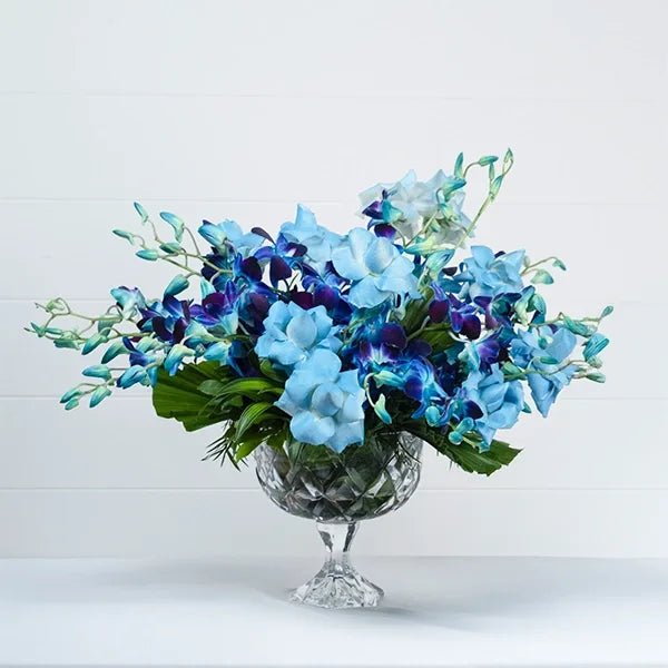 blue orchid and rose arrangement in crystal vase front view 2