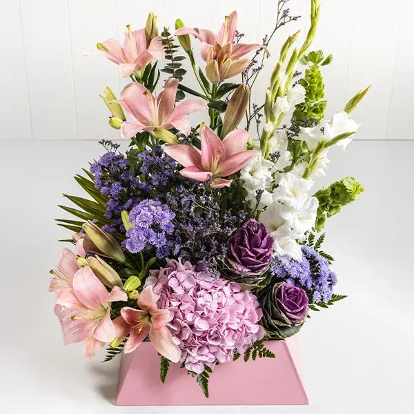 mixed flower box arrangement of pink asiatic lilies hydrangea barcia purple white glads blue daisies front view