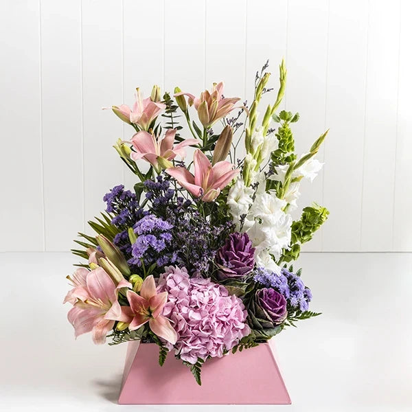 mixed flower box arrangement of pink asiatic lilies hydrangea barcia purple white glads blue daisies front view