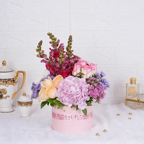 jumeila roses peach roses pink snap dragons in a light pink box front view