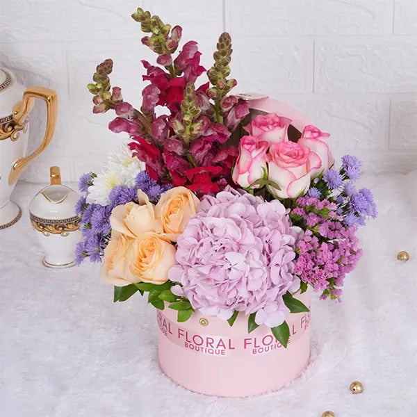 jumeila roses peach roses pink snap dragons in a light pink box front view 2