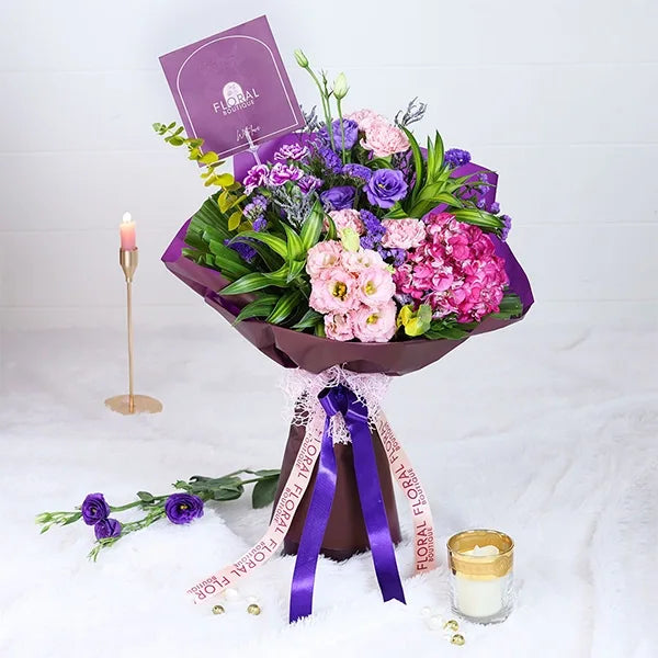hydrangea and carnation bouquet in purple wrapping paper front view