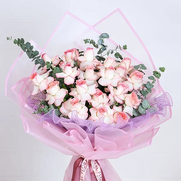 jumilia pink rose bouquet in pink wrapping paper close up view