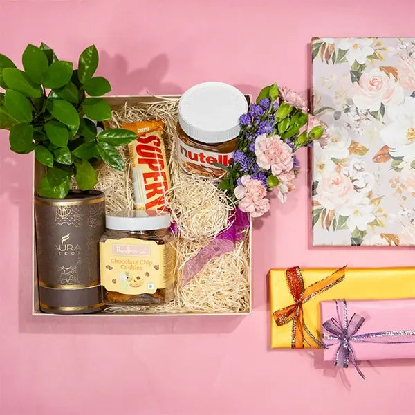 curated hamper with artisanal chocolates and aromatic candles top view