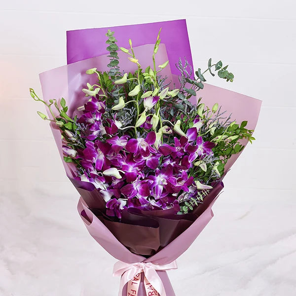 orchid bouquet with purple wrap close up view