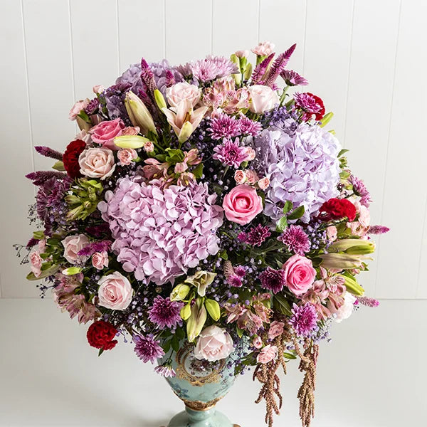 fancy flower vase arrangement of hydrangea asiatic lily pink roses closeup view