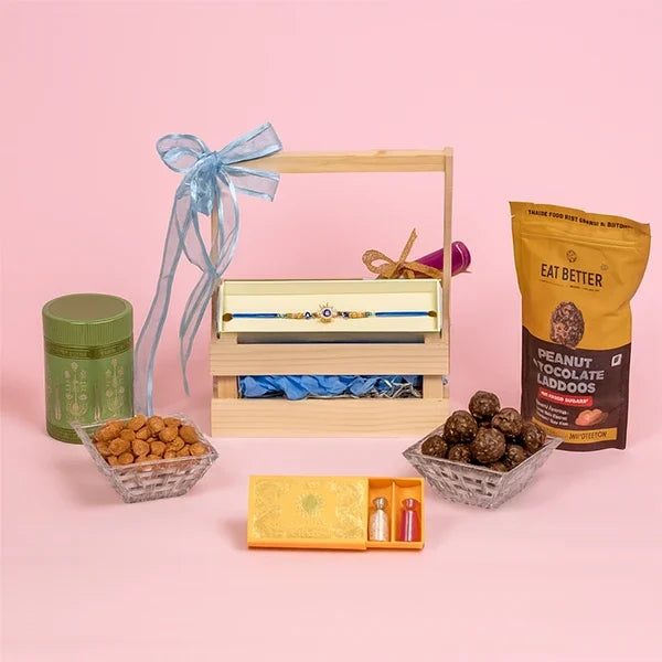 golden evil eye sun rakhi with millet laddu and almonds hamper front view