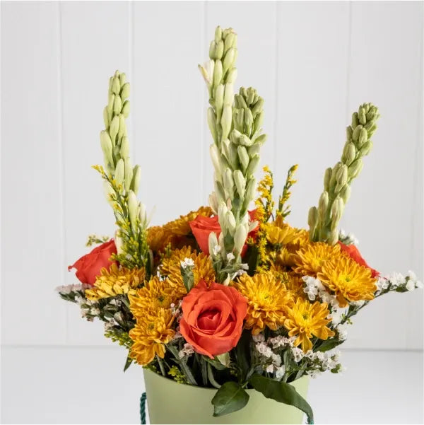 orange chrysanthemums tuberose stems goldenrod stems cone shaped box close up view
