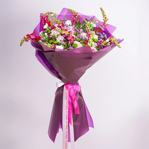 mix flower bouquet of soft pink roses with carnations and purple alstroemeria front view