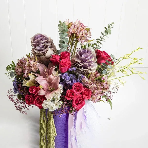 purple round flower box arrangement of dark pink roses and pink alstroemeria flowers front view 2