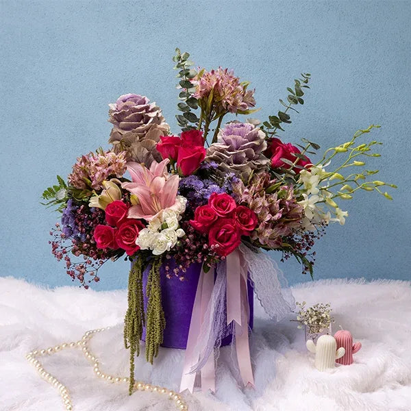 purple round flower box arrangement of dark pink roses and pink alstroemeria flowers front view