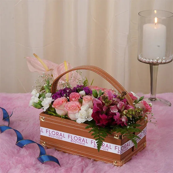 jumelia roses pink anthurium dark pink snapdragons in leather basket front view