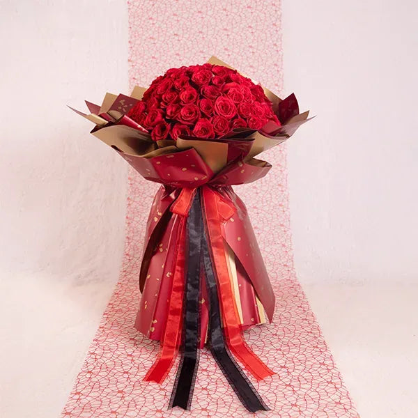 100 red roses bouquet wrapped in red and gold paper front view 2