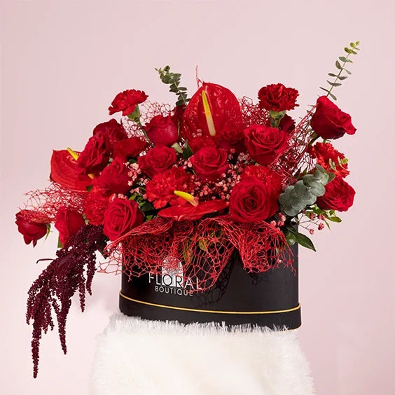 red flower box arrangement of 20 red roses with red carnations front view 3