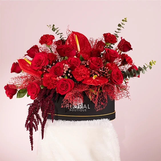 red flower box arrangement of 20 red roses with red carnations front view