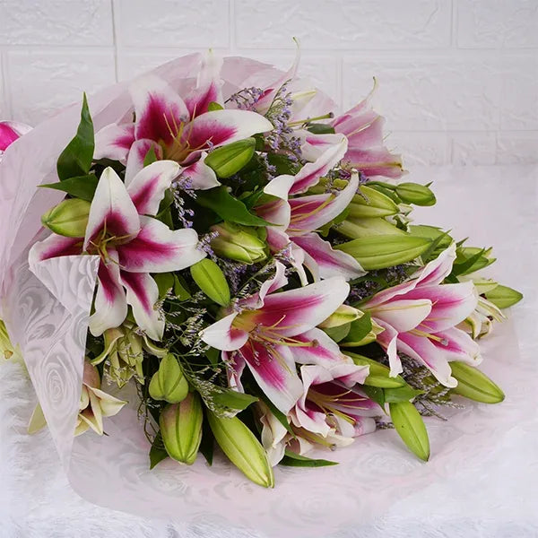 oriental lily bouquet warped in pale pink paper top view