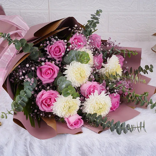 pink and white bouquet of pink roses wrapped in pale pink paper top view